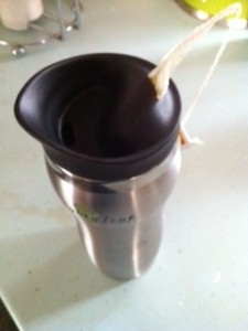 a stainless steel cup with a black lid