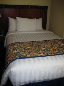 a bed with white pillows and a floral blanket
