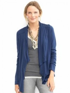 a woman wearing a blue cardigan and necklace