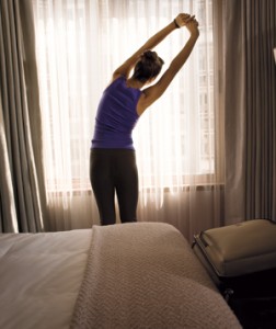 a woman stretching her arms in a hotel room