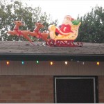a santa claus on a sleigh with reindeers on top of a roof