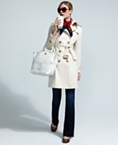 a woman in a white coat holding a white bag and a white purse