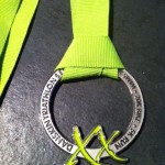 a silver medal with a green ribbon