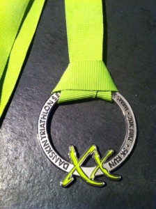 a silver medal with a green ribbon