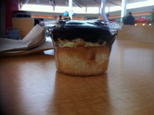 a cupcake with chocolate frosting on a table