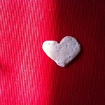 a heart shaped cracker on a red surface