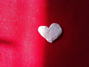 a heart shaped rock on a red surface