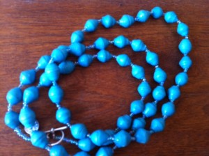 a blue beaded necklace on a wood surface