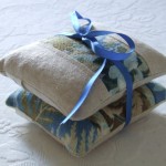 a stack of fabric bags tied with a blue ribbon