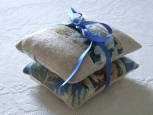 a stack of fabric bags tied with a blue ribbon