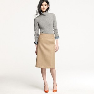 a woman in a turtleneck and a tan skirt