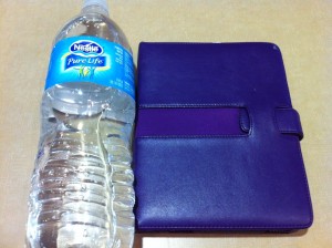 a water bottle next to a blue wallet