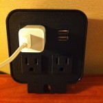 a black outlet with a white cord plugged into it