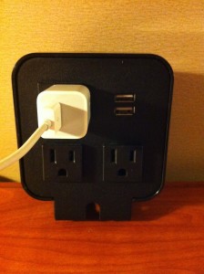 a black electrical outlet with a white cord plugged into it