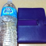 a water bottle next to a blue wallet