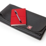 a red notebook and pen on a black case