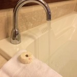 a donut on a towel next to a faucet