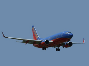 a blue and red airplane flying in the sky
