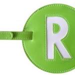 a green luggage tag with a letter