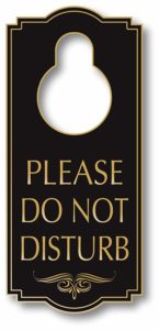 a black and gold sign with a circle hole