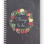 a spiral bound notebook with a floral wreath